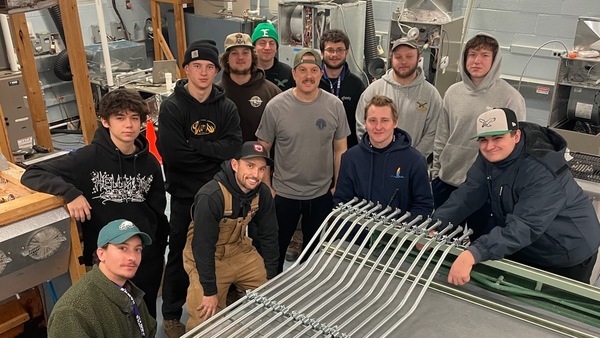 Students in Cape Tech’s Electrical Apprenticeship program working with bent electrical conduit pipes used for a class project.