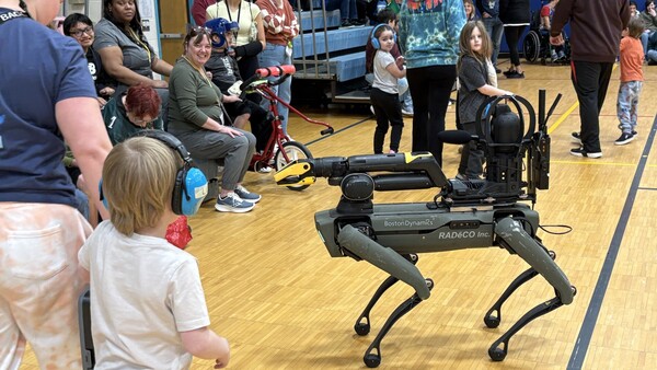 Students and staff interacting with the robotic dogs